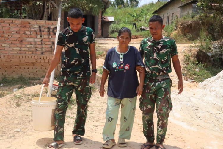Keakraban Satgas TMMD ke-127 Kodim 0301/Pekanbaru dengan Ibu Sarianis di Tengah Terik Matahari